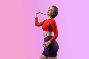 Vücut uzunluğunun tamamı atletik ve sportif genç bir kadın tarafından izole edilmiş arka planda ip atlarken çekildi. Sağlıklı aktif ve vücut bakımı yaşam tarzı.