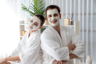 Yüzü kremli, bornozlu mutlu bir çift tatil boyunca kaplıca salonu ya da otelin huzurlu atmosferinin tadını çıkarıyor. Şımarık yüz spa 'sı ve cilt bakımı, esans rahatlığı. Sessiz.