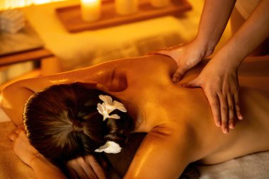 Beyaz kadın müşteri stres önleyici spa masajının keyfini çıkarıyor ve lüks otel ya da otelde sıcak mum ışığında güzellik teniyle eğleniyor. Sessiz.