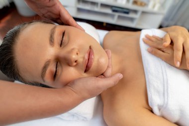 Kafkasyalı kadın stres önleyici kafa masajından ve lüks tatil beldesi ya da otel spa salonundaki modern ışık ortamında yüz güzelliği eğlencelerini şımartmaktan hoşlanıyor. Sessiz.