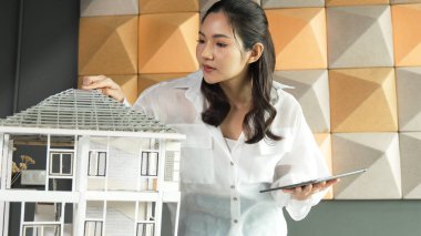 Tablet kontrol evi modelini kullanan güzel bir proje yöneticisi. Mimar mühendisinin portresi tabletteki veri analizini kullanarak bina inşaatını denetliyor. İş inşaat konsepti. Yönlendirici.