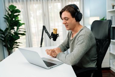 Sunucu kanalı, gülümseyen akıllı yayıncı kaydı, senaryosu ve akıllı telefonuyla sosyal medyada sohbet programı, kulaklık takarak modern ev stüdyosundaki video flamalarını kaydediyor. Bireysel.