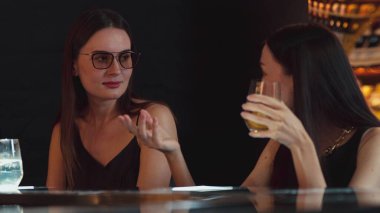 Gülümseyen güzel bir müşteri, lüks bir barda arkadaşlarıyla konuşuyor. Bir anda barmenlere portakallı kokteyl ikram ediyor. Klüpte sosyete ortamının tadını çıkarıyor. Vinosity.