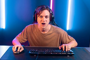 Kazanmak için çevrimiçi oyun oynayan akıllı flama makinesinin sunucu kanalı, neon ışıklı odada seçilen takım yarışması için izleyicilerle birlikte canlı yayında canlı yayında kulaklık takıyor. Bireysel.