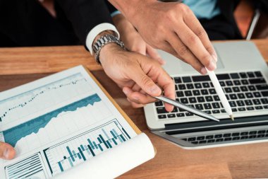 Ofis masasındaki finansal veri raporlarını analiz eden çeşitli bir grup iş analisti. Stratejik pazarlama planlaması için iş istihbarat analizine göre grafikler ve grafikler.