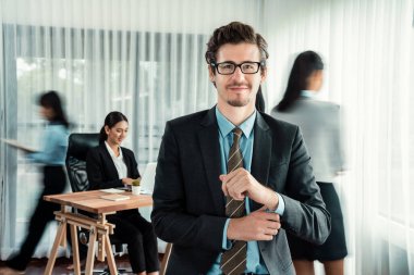Kameraya bakan mutlu iş adamının portresi iş dünyasındaki hareketlerin hareket bulanık arka planına sahip. Habiliment