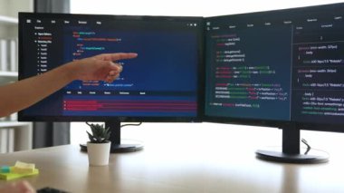 Yavaş çekim arkası yazılım geliştirici mühendisi bilgisayar programlama için birlikte çalışarak hata ayıklama kodunu çözüyor, ofiste monitörde karmaşık algoritmaları çözüyor. Filizlenen