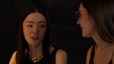 Güzel giyinen bir kadının portresi lüks bir tezgah içecek barında arkadaşıyla sohbet ediyor. Gece kulübünde sosyetik etkileşim sahnesinin özünü yakalıyorum. Vinosity.