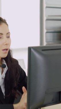 Ofiste çalışan kulaklık takan işadamları uzak müşteri ya da meslektaşlarını desteklemek için çalışıyorlar. Arama merkezi, tele pazarlama, müşteri destek acentesi telefon görüşmesinde hizmet sunar.