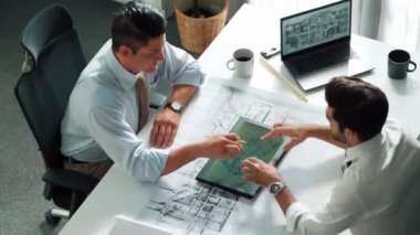 Proje planının dizüstü bilgisayarında ev inşaatı ve ekipmanlarıyla toplantı masasında oturup plan yazarken yöneticilerin konuşmalarının ve ev inşaatı hakkında tartışmalarının en üst görüntüsü. Hizalama.