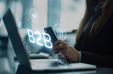 İş adamı B2B peyzajında geziniyor, iş-iş bağlantılarını geliştirmek için kullanım teknolojisi kullanıyor. B2B etkileşimlerini yeniden şekillendirir, iş stratejilerindeki yenilikleri tetikler. EIDE