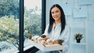 Modern ofisteki hata noktasını incelemek ve incelemek için sol ve sağ görüşlü yetenekli genç, güzel beyaz mimar asansör evi modelini kapatın. Tertemiz..