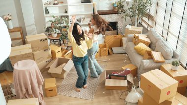 Taşınırken oturma odasında mutlu lezbiyen aşıklar dans ediyor. Birkaç arkadaş müzik eşliğinde salonda karton kutularla dans ederek serbest dans ediyorlar. Yeniden yerleştirme. Myrmidon.