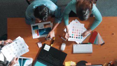 Ekip toplantısına katılıp fikir hakkında konuşurken proje yöneticisinin yazma fikrinin en üst görüntüsü. Renk paletine bakarken ve kağıda fikir yazarken profesyonel tasarımcı logosu. Sempozyum.