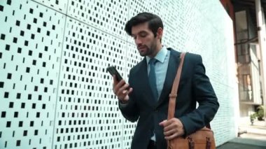 İş adamı telefona cevap verir ve iş yatırımları hakkında konuşur. İş planı, pazarlama stratejisi ya da çalışma hakkında konuşmak için akıllı telefonla konuşurken sokakta yürüyen mutlu bir yönetici. Sevinçli..