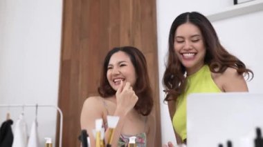 İki kadın nüfuzlu partner sosyal medya veya blog için canlı yayın yapan video klip inceleme derisi çekiyorlar. Canlı kozmetik stüdyo ışığı olan genç bir kız çevrimiçi pazarlama kayıt oturumu yayını için.