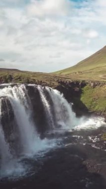 Kirkjufell dağ manzarasının ve İzlanda yazındaki şelalenin hızlandırılmış görüntüleri. Kirjufell, İzlanda 'yı ziyaret etmek için turistleri çeken en güzel ve en çok fotoğraflanan dağdır..
