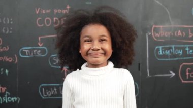 Mutlu Afrikalı öğrenci gülümsüyor ve mühendislik komut ya da kodlama sistemiyle ayakta duruyor. BTMM teknoloji sınıfında yazıyor. Çocuk bilim teorisi ya da yenilikçi. Etkinlik.