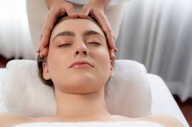 Kafkasyalı kadın stres önleyici kafa masajından ve lüks tatil beldesi ya da otel spa salonundaki modern ışık ortamında yüz güzelliği eğlencelerini şımartmaktan hoşlanıyor. Sessiz.