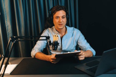 Akıllı yayıncının sunucu kanalı, canlı sosyal medyada canlı yayında konuşma programı ile birlikte modern stüdyoda, kayıt cihazıyla dinleyiciye senaryo okumaktadır. Bireysel.