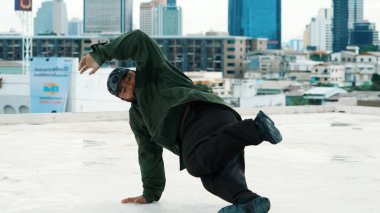 Profesyonel Asyalı break dansçı B çocuk dansı yaparken çatıda çok kültürlü arkadaşlar var. Genç modern dans grubu hip hop hareketi yapıyor. Tarz, moda, aksiyon. Açık hava sporu 2024. Hiphop.