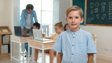 Kafkasyalı sevimli öğrenci kameraya bakarken arkadaşı mühendislik kodu ya da kodlama komut yazmayı öğreniyor. Profesyonel akıllı öğretmen yapay zekayı öğretirken komut kontrol ediyor. Pedagoji.