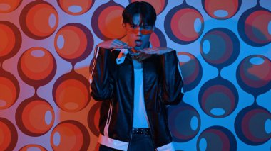 Tesadüfi tişörtlü beyaz dansçı parti sahnesinde dururken break dans yapıyor. Profesyonel hipster kameraya bakarken elini ve kolunu hareketli ve serbest stil şarkısına uzatıyor. Mutluluk.