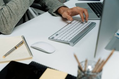 Gündelik işlerde çalışan kıyılmış işadamı, modern ofisteki bilgisayar ekranında borsa borsa veritabanını analiz ederek sunum için iş pazarlama raporunu araştırmak için bilgisayarı kullanıyor. Bireysel.