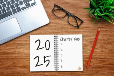 2025 Mutlu Yeni Yıl Kararları Hedef Listesi ve Planları Ayarlama - Yeni yıl hedefleri ve kararları belirleme planları hakkında not defteriyle birlikte iş yeri masası. Değişim ve sevinç kavramı.