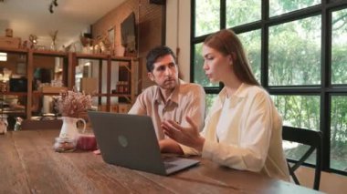 Baharda Cafe Garden 'da dizüstü bilgisayarda çalışan genç bir çift kahve dükkanındaki dinginlik ortamının tadını çıkarıyor. Uzaktan çalışan ya da blog yazan dijital göçebe ya da üniversite öğrencisi. Yararlı