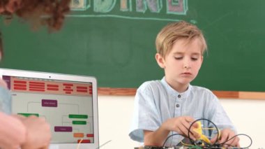 Kafkas akıllı çocuk kök teknoloji dersinde tornavida kullanarak ana tahtayı tamir ederken aynı zamanda gülümseyen öğrenci de dizüstü bilgisayar ekranı kodlu elektronik makineyi incelemek için birlikte çalışıyor. Pedagoji.