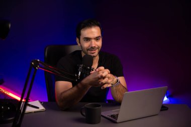 Yayıncı, fanclub dinleyicisiyle mikrofon kullanarak konuşuyor. Mor neon ışıklı modern stüdyoda yaratıcı olumlu düşünce konseptiyle canlı yayında finansal sorunları tartışıyor. Tahmin et..