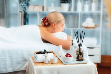 Aromaterapi masajı gündüz atmosferinde ya da spa salonunda bulanık bir kadına odak dekor ve spa aksesuarları kurarak tatil köyünde ya da otel arka planında keyifli aroma spa masajı yapan bir masaj. Sessiz.