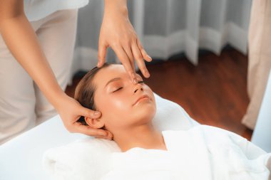 Kafkasyalı kadın stres önleyici kafa masajından ve lüks tatil beldesi ya da otel spa salonundaki modern ışık ortamında yüz güzelliği eğlencelerini şımartmaktan hoşlanıyor. Sessiz.