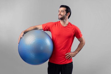 Vücut uzunluğunun tamamı atletik ve sportif genç bir adam tarafından izole edilmiş arka planda topu ayakta tutarken çekildi. Sağlıklı aktif ve vücut bakımı yaşam tarzı.