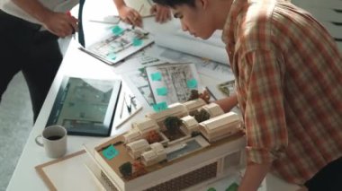 Akıllı mimar ya da inşaat mühendisi bina yapısı fikrini not edip plana yapıştırıyor. Yöneticinin çeşitli meslektaşları ve ev planlarıyla birlikte çalıştığı hava görüşü. Hizalama.