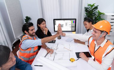 Çeşitli inşaat mühendisi ve müvekkil grupları, mimari proje üzerinde başarılı bir anlaşma yaptıktan, inşaat planını gözden geçirdikten ve toplantı masasında plan oluşturduktan sonra kutlama ve beşlik çakışma yaptılar.