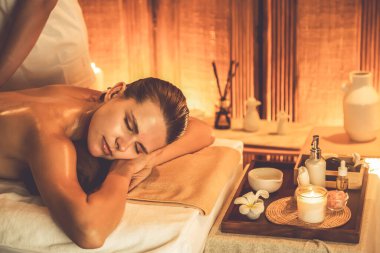 Beyaz kadın müşteri stres önleyici spa masajının keyfini çıkarıyor ve lüks otel ya da otelde sıcak mum ışığında güzellik teniyle eğleniyor. Sessiz.