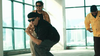 Genç yakışıklı hippi, çok kültürlü arkadaşlarla dans ederek break dans yapıyor. Happy dans takımı binadaki hip-hop müziğine geçiyor. Enerjik sokak dansı. Açık hava sporu 2024 hiphop..
