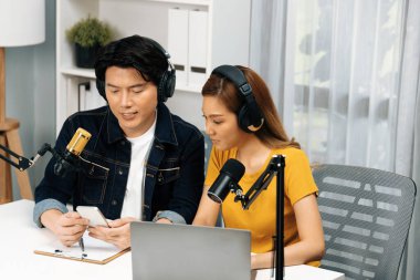 Gülümseyen radyo etkili sunucular, kulaklık takıp sosyal medyayı canlı yayında dinleyicilere telefon ve dizüstü bilgisayarla canlı yayınlıyorlar. İnfobahn.