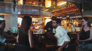 VIP grubu, barın karşısında oturmuş arkadaşlarıyla ya da barmenlere kokteyl hazırlarken karışık kokteyl içen çiftle yaşam tarzı yolculuklarını tartışıyor tezgahın üzerindeki arka taraftaki süslü Noel ağacını hazırlıyorlar. Vinosity.