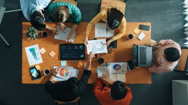 Becerikli iş adamlarının pazarlama fikrine ilişkin üst düzey bir görüş, bir grup yatırımcı hisse senedi borsası grafiği veya veri analiz belgesine bakarken dinleme ve planlama stratejisi sunarken ortaya atıldı. Cemaat.