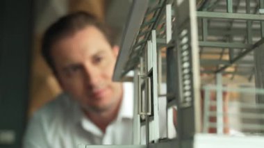 İnşaat yapısını ve hata noktalarını incelerken profesyonel mühendis yüzünün ev modeline bakması. Yetenekli proje yöneticisi ev modelini kontrol ediyor. İş tasarımı konsepti. Yönlendirici.