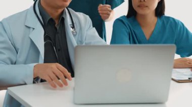 Hastane masasında birlikte çalışan ve tıbbi tedavi planlayan çeşitli profesyonel sağlık görevlileri. Takım çalışması başarılı hastalıklara ve hastalıklara yol açar. Ağır çekim. Katı.