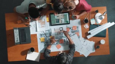 Pazarlama ekibi tasarım planlarken yöneticinin planlarını yukarıdan aşağıya incelemek. Mimar mühendisin birlikte çalıştığı, fikir paylaştığı ve proje planına not aldığı hava görüşü. Sempozyum.