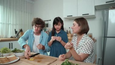 Modern mutfakta oturan ve meyve yiyen mutlu beyaz anne ve babalar. Enerjik aile birlikte vakit geçirerek meyve ya da mutfak gereçleri ve meyveli sağlıklı meyveler yemekten zevk alır. Pedagoji.
