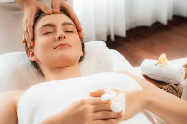 Kafkasyalı kadın stres önleyici kafa masajından ve lüks tatil beldesi ya da otel spa salonundaki modern ışık ortamında yüz güzelliği eğlencelerini şımartmaktan hoşlanıyor. Sessiz.