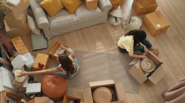 Mutlu online satıcı birlikte çalışıyor ve oturma odasında paket paketliyor. Asyalı girişimci teslimat ürünlerini paketliyor ya da sipariş kutusu göndermeye ya da göndermeye hazırlanıyor. Çevrimiçi iş kavramı. Myrmidon.