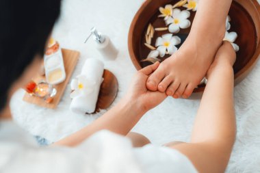 Kadınlar lüks spa salonlarında keyifli ayak masajlarına devam ederken, masör de hafif gün ışığı atmosferinde refleksoloji terapisi veya otel ayak spa 'sında. Sessiz.