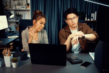 Satış müdürleri e-posta göndermeyi beklerken, gece geç saatlerde modern ofiste mesai saatlerinde rapor veri analizi için fazla mesai ile birlikte çalışıyorlar. İnfobahn.